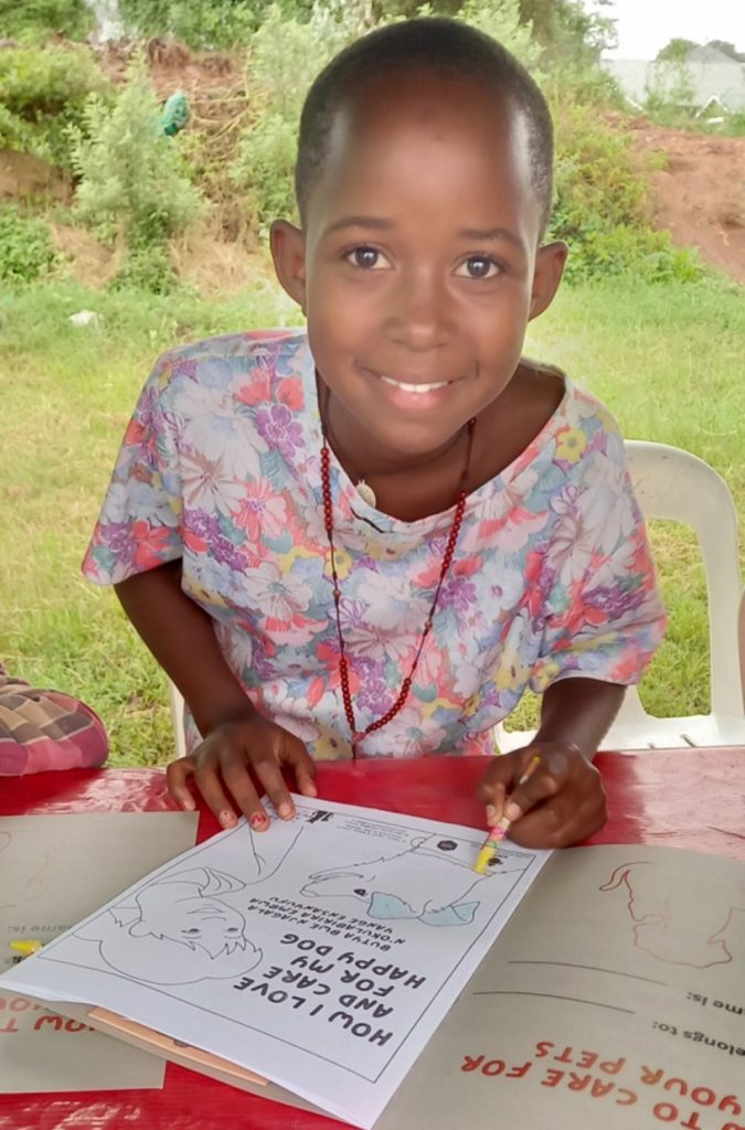 Young girl shading in her coloring book at the Uniquely Paws sponsored World Rabies Day 2023 free community clinic in Kansanga Photo courtesy of Meg Jaquay