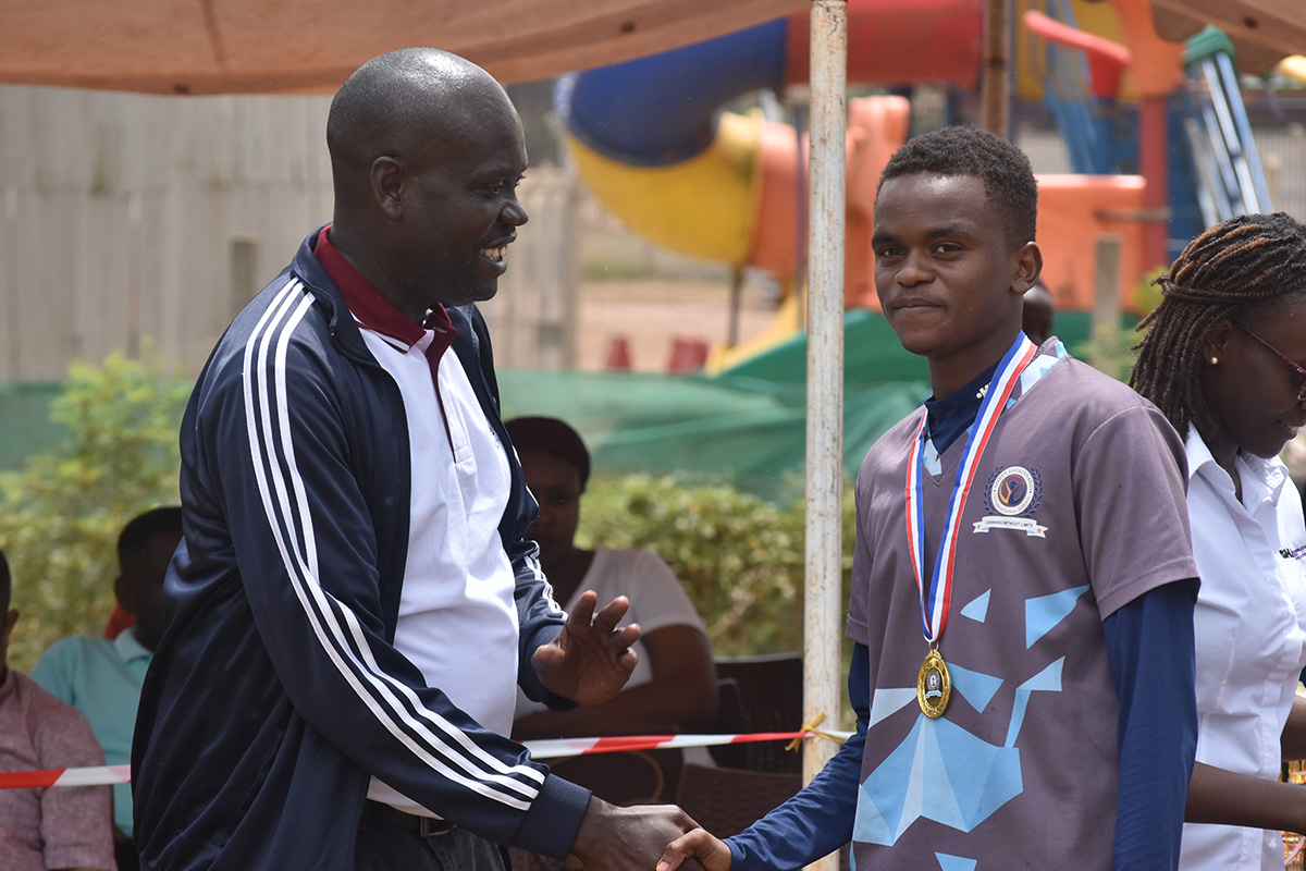 school co ordinator Mr Emannuel Opuwa congratulating student on outstanding sports performance